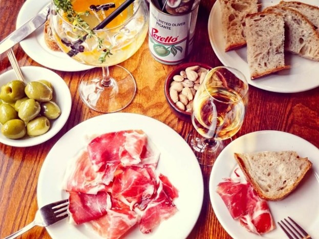 An overhead shot of a table of food with two glasses of wine