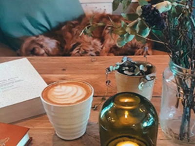 A table filled with a coffee, candles and a plant