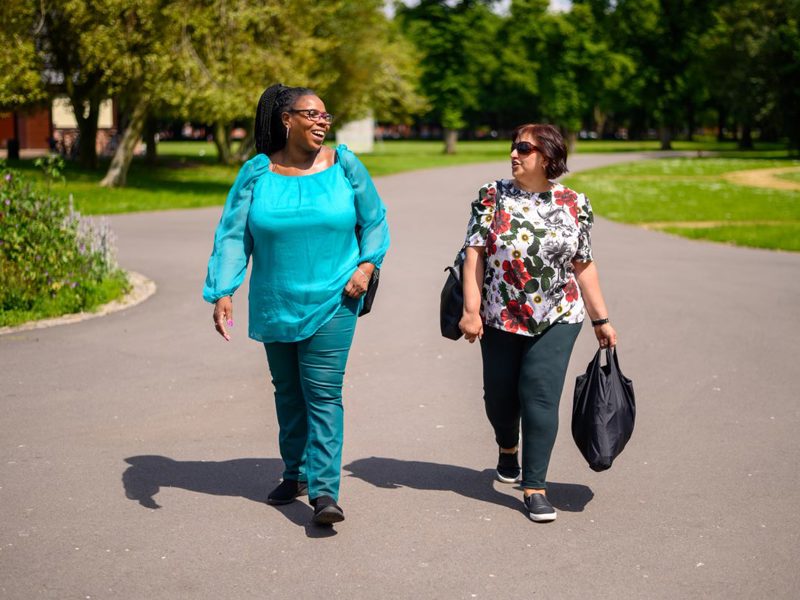 Two women walking in the sunshine