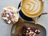 Shot from above of a cup of coffee, a hot chocolate and a brownie 